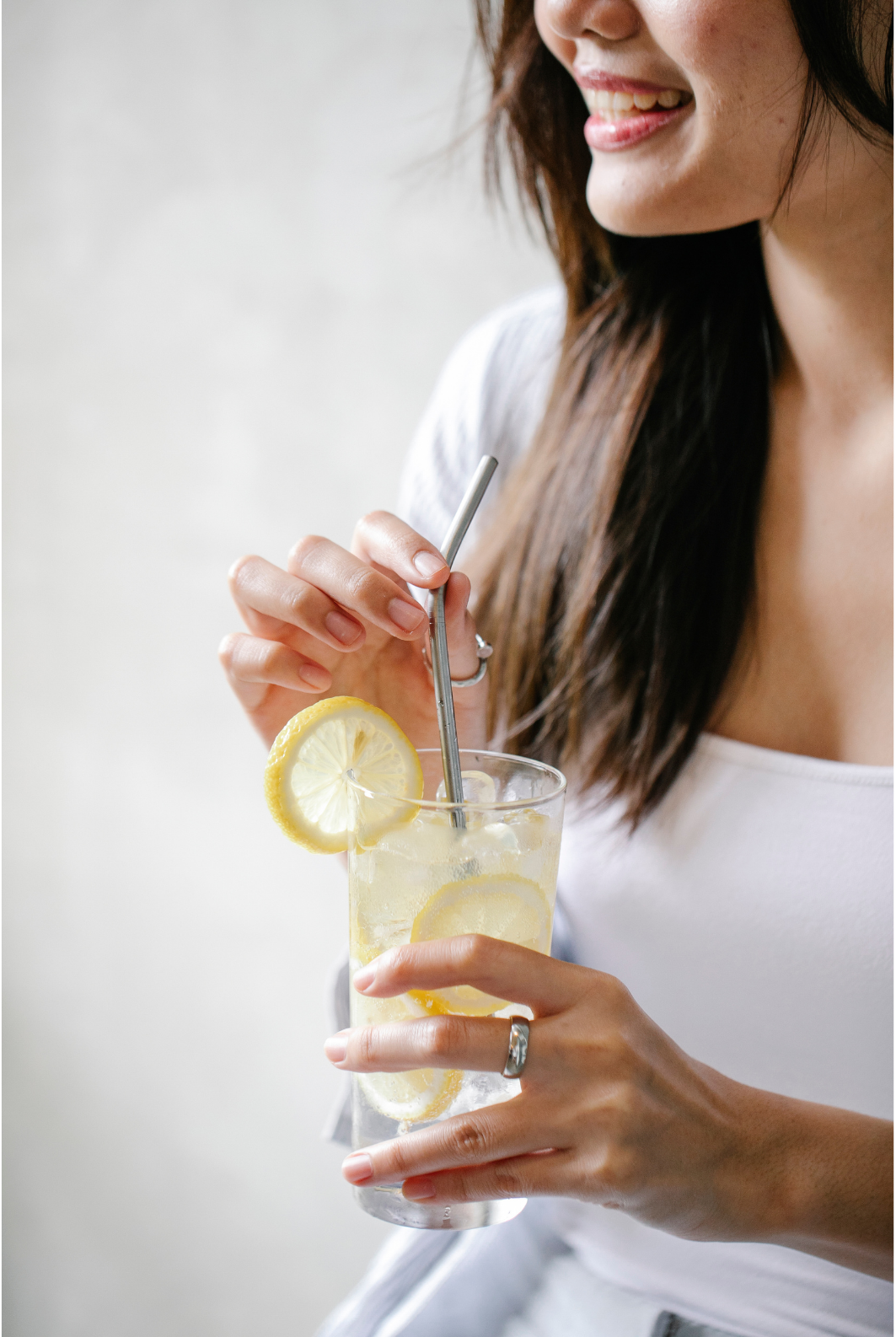 Femme tenant un verre de sève de bouleau fraîche bretonne citronnée